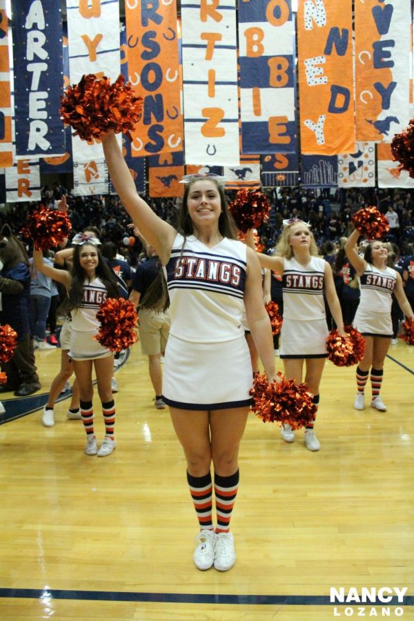 Varsity cheerleaders Chloe Garcia, Kate Howard, Bailee Smith and Haley Sullivan welcome the classes as they enter the gym for the homecoming pep rally.