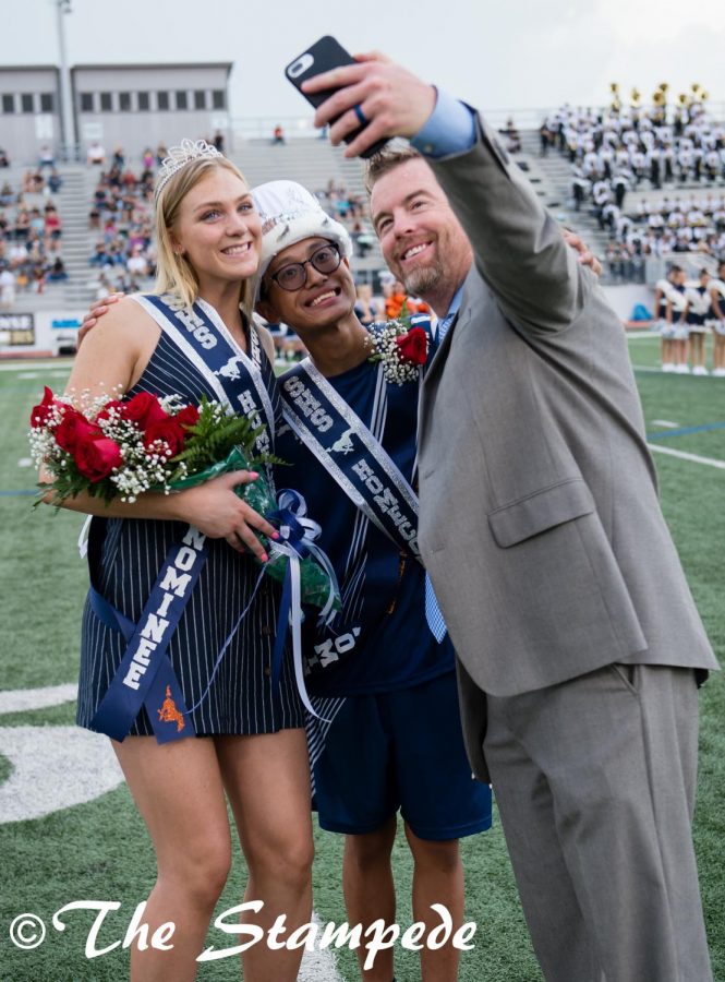 Principal Shae Creel takes a quick selfie with Queen Hannah Hooks and King Qui Le.  The pregame Homecoming festivities ended shortly before a storm caused a weather delay of the game against Plano East.