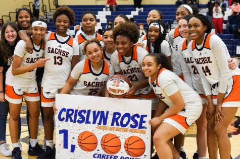 The girls varsity basketball team celebrates junior Crislyn Roses career 1,000 points at the conclusion of their first round playoff win against Dallas Skyline.